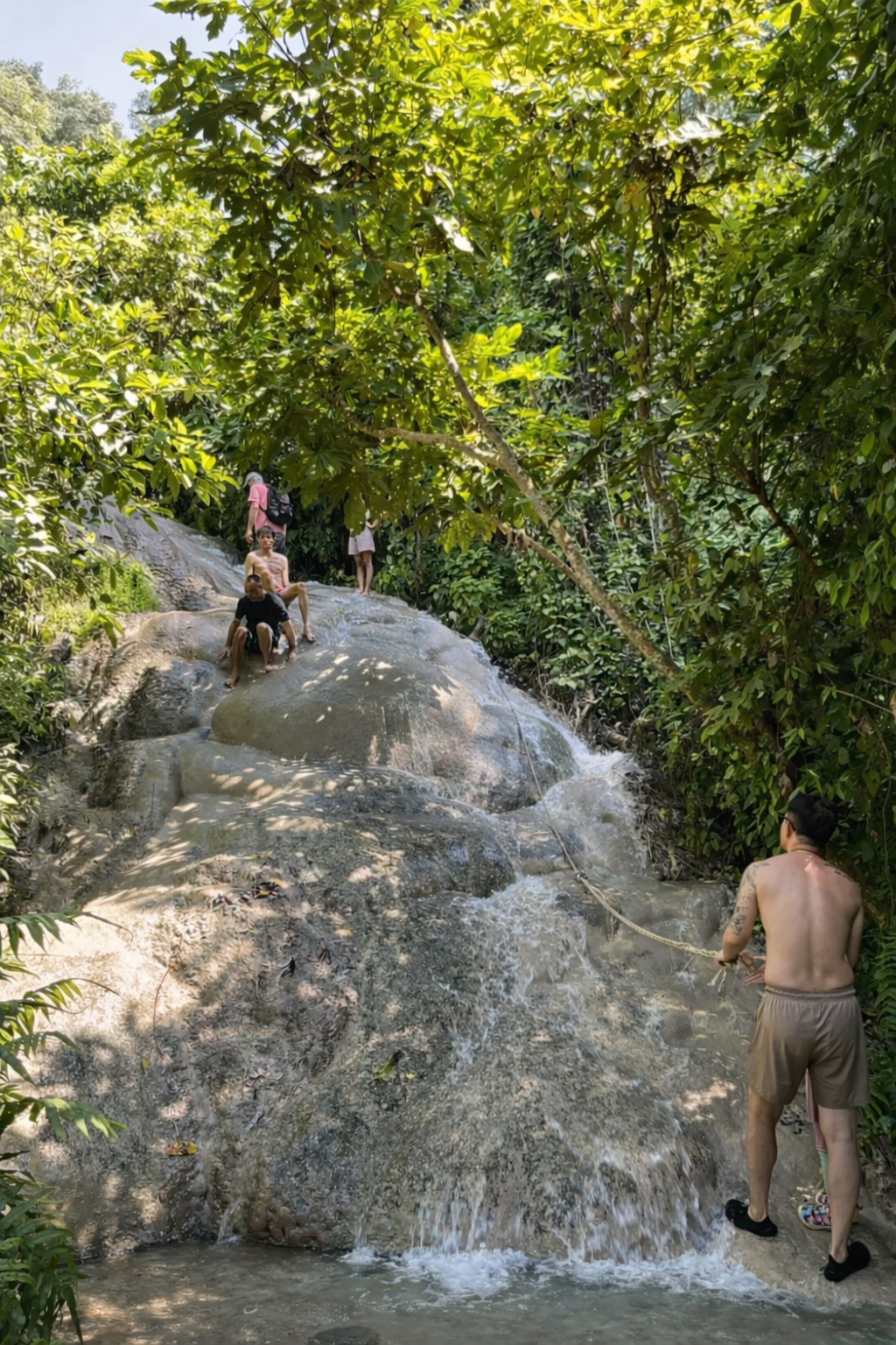 Visitors climbing barefoot up Bua Tong Sticky Waterfall